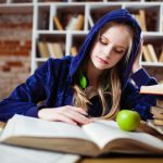 "A girl studying at a desk."